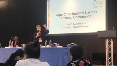 Image of woman talking in front of Rape Crisis presentation